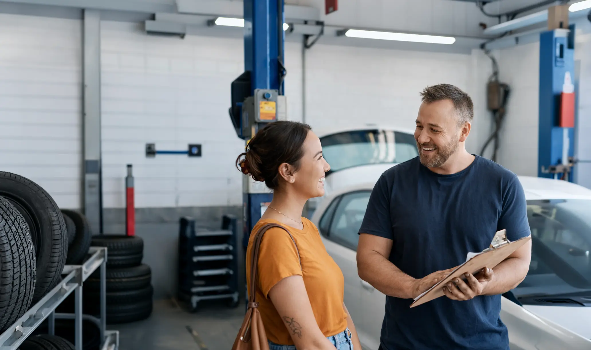 Mechanic with female customer in workshop at Nandrews Garage